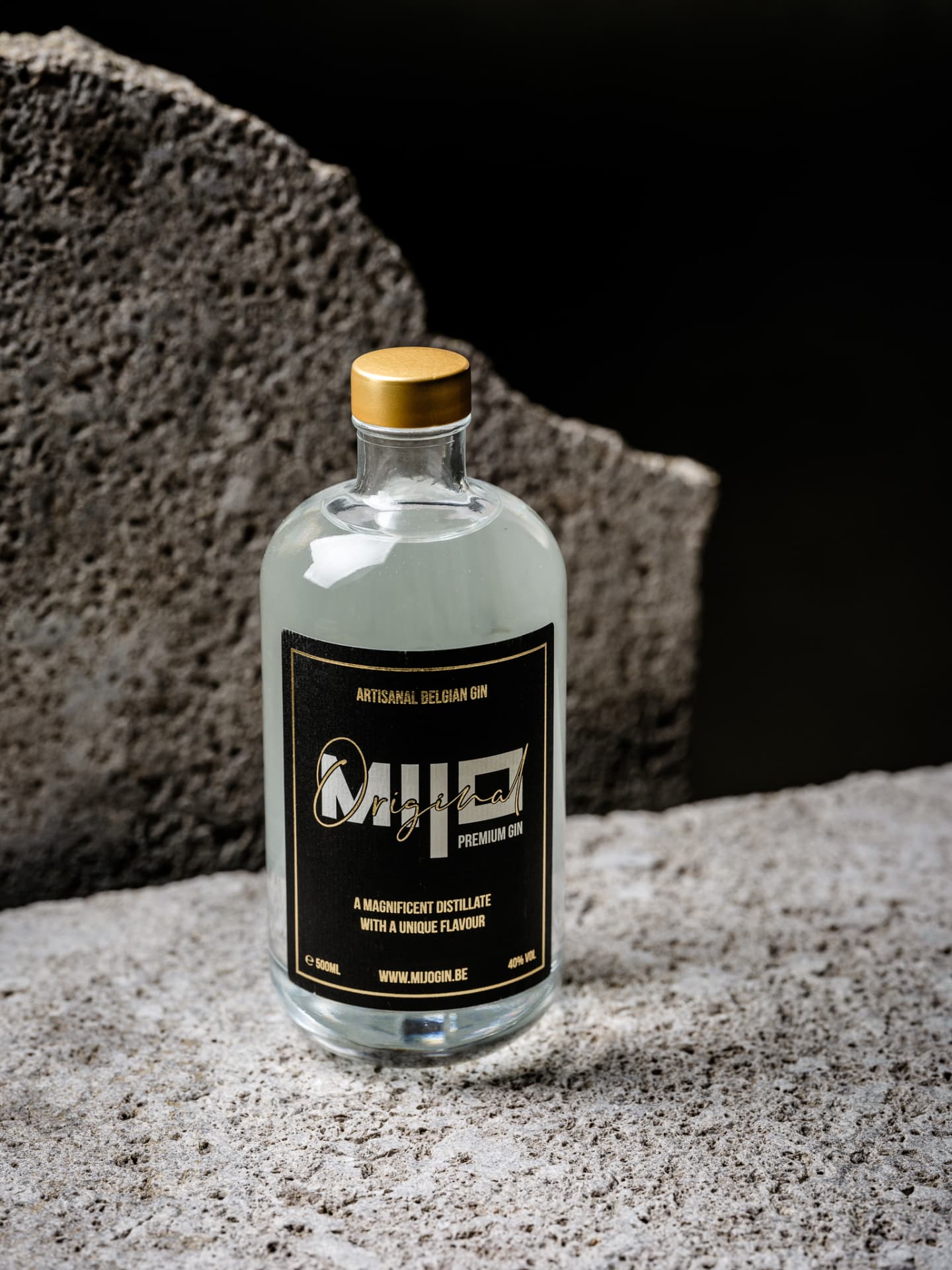 De Mijo Gin-fles in warm licht tegen een donkere getextureerde achtergrond